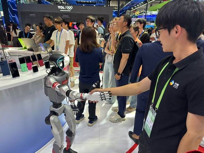 지난 16일 오후 중국 베이징 국제전시컨벤션센터에서 열린 제3회 중국국제공급망촉진박람회에서 참석자가 중국 IT기업 레노버의 휴머노이드 로봇과 악수를 하고 있다. 연합뉴스