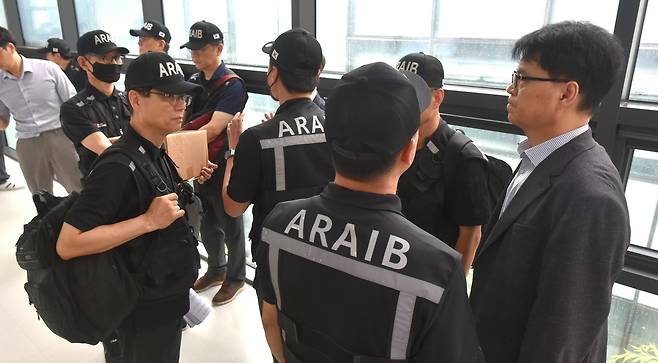 항공·철도사고 조사위원회(ARAIB) 관계자들이 19일 오후 전남 무안국제공항에서 열린 '12.29 여객기 참사 엔진 정밀조사 결과 현장 브리핑'에 참석하던 중 유가족들의 항의로 인해 회의실 입장을 대기하고 있다. /뉴스1