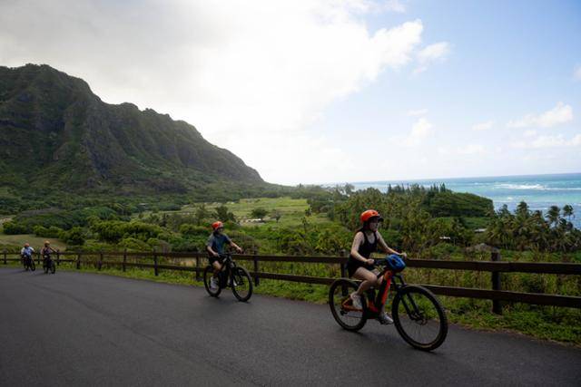 미국 하와이주 오아후 쿠알로아 랜치를 방문한 여행객들이 전기산악자전거를 타고 있다.