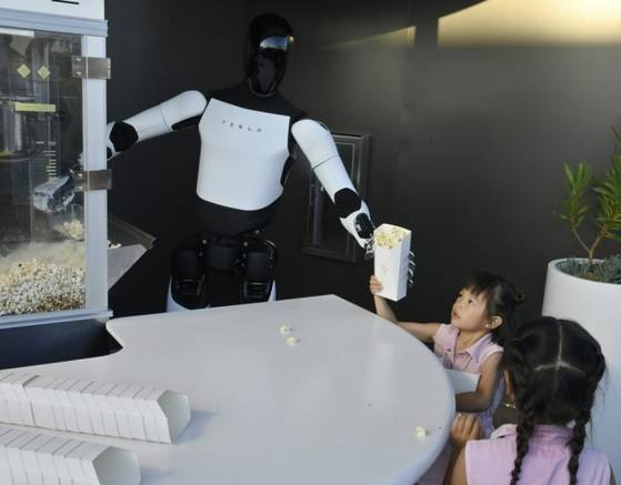 로봇 ‘옵티머스’가 어린이에게 팝콘을 건네는 모습. UPI=연합뉴스
