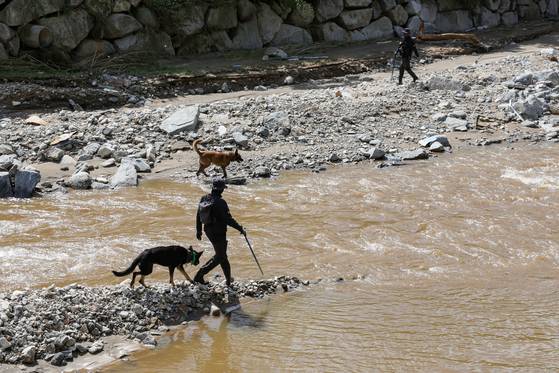 22일 경기도 가평군 조종면 마일리에서 경찰이 탐지견과 함께 실종자 수색작업을 벌이고 있다. 연합뉴스