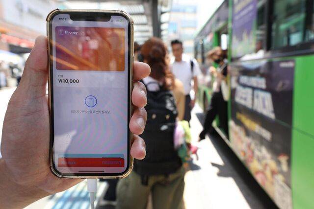 22일부터 애플 아이폰과 애플워치에서 티머니와 연동한 선불 교통카드를 쓸 수 있게 됐다. 사진은 서울의 한 버스정류장에서 아이폰으로 티머니 교통카드를 실행하고 있는 모습. 연합뉴스