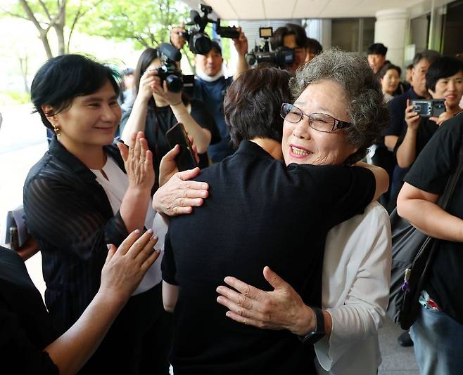 61년 전 자신을 성폭행하려던 남성의 혀를 깨물어 중상해 혐의 유죄 판결을 받았던 최말자(78)씨가 23일 부산지법에서 열린 재심 첫 공판을 마치고 법정을 나서며 변호인과 여성단체와 포옹하고 있다. 연합뉴스