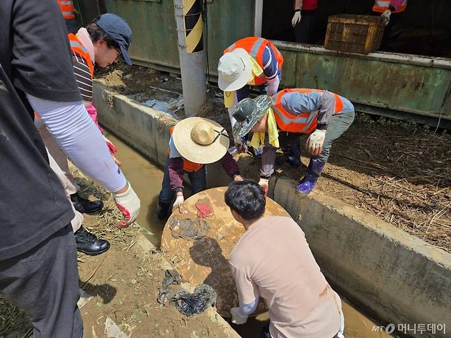 22일 충남 예산을 찾아 수해 복구 봉사활동에 나선 국민의힘 의원들이 수마에 휩쓸린 냉장고 등 잔해를 치우고 있다./사진=박상곤 기자