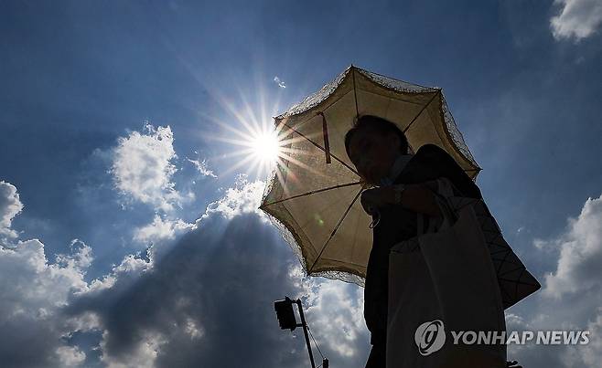 양산 필요한 무더위 (대구=연합뉴스) 윤관식 기자 = 대구에 폭염경보가 이어진 23일 동대구역 광장에서 한 시민이 양산을 쓰고 이동하고 있다. 2025.7.23 psik@yna.co.kr