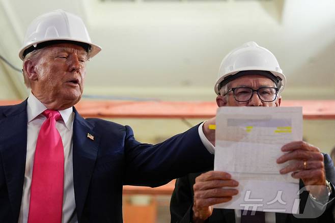 도널드 트럼프 미국 대통령이 24일(현지시간) 워싱턴 D.C.에 위치한 연방준비제도(연준) 건물에서 진행 중인 리모델링 공사현장을 둘러보는 중 제롬 파월 의장이 트럼프가 건넨 새로운 공사비용 관련 문서의 수치를 확인하고 있다. 2025.7.24 ⓒ 로이터=뉴스1