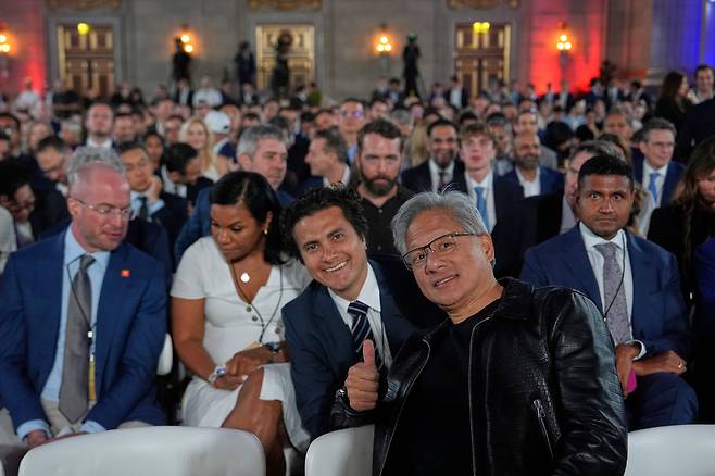 트럼프 연설 기다리는 젠슨 황 - 젠슨 황(맨 앞줄) 엔비디아 CEO(최고경영자)가 23일 미국 워싱턴DC에서 열린 '인공지능 경쟁 승리 서밋' 행사에서 도널드 트럼프 미국 대통령 연설을 기다리며 사진을 찍고 있다. /AP 연합뉴스