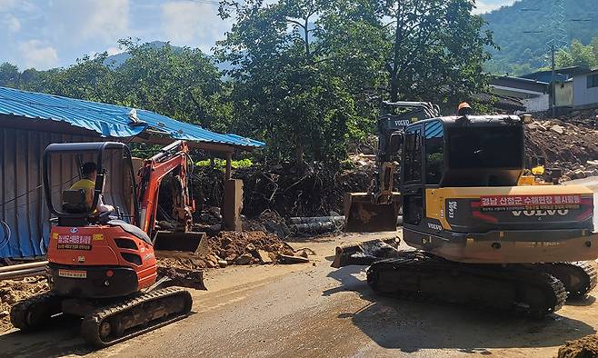 24일 경남 산청군 병정마을에서 경북 산불피해주민대책위 청송지구 소속 회원들이 중장비를 동원해 수해 복구 작업을 돕고 있다.
