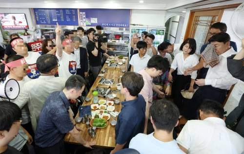 25일 간담회를 위해 완주군 한 음식점을 찾은 우범기 전주시장이 통합 반대 일행들로부터 물벼락을 맞고 얼굴을 닦고 있다. 독자제공