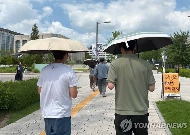 인당 1개씩…여름 버틸 양산 필요해 (서울=연합뉴스) 최혜정 인턴기자 = 지난 23일 오후 남성 두 명이 양산을 1개씩 들고 서울 서대문구 백양로 거리를 걸어가고 있다. 2025.7.25