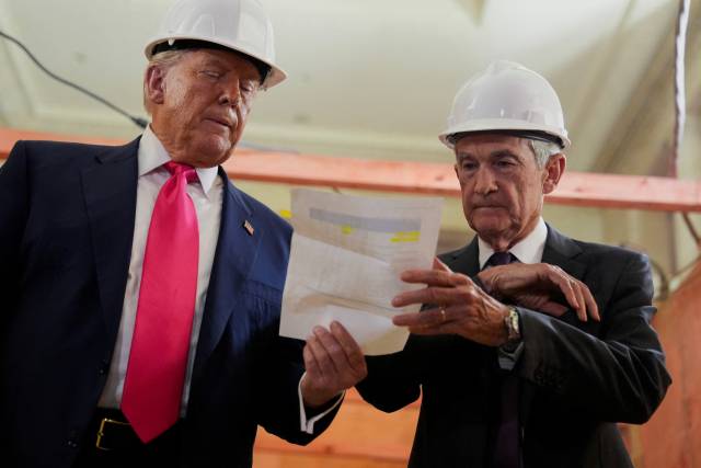 도널드 트럼프 미 대통령이 24일(현지 시간) 워싱턴 내 연방준비제도 리모델링 현장을 방문해 리모델링 비용이 연준이 발표한 것보다 많이 들어갔다는 내용의 서류를 제롬 파월 연준 의장에게 건내고 있다. 서류를 살피던 파월 의장은 5년 전에 이미 완공된 건물 비용이 추가된 것이라고 반박했다. 로이터연합뉴스