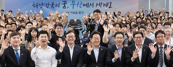 부산서 세 번째 타운홀 미팅 - 이재명 대통령이 25일 부산 부경대에서‘부산의 마음을 듣다’라는 주제로 열린 타운홀 미팅을 마친 뒤 손을 들어 기념 촬영을 하고 있다. 부산 시민 200여 명이 초청됐고, 전재수 해양수산부 장관, 김경수 지방시대위원장, 박형준 부산시장 등이 참석했다. /연합뉴스