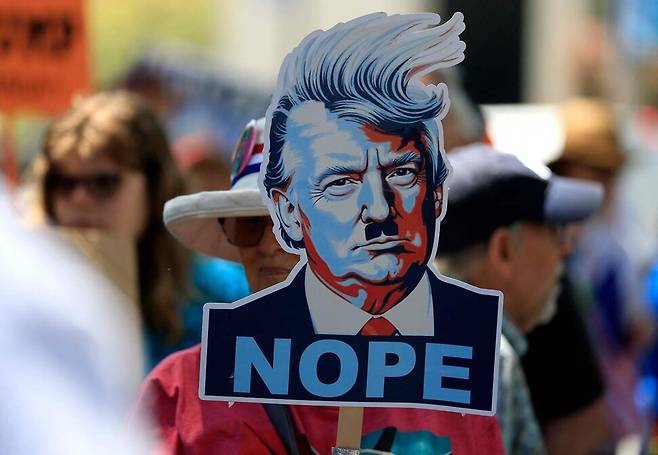 2025년 7월17일 미국 캘리포니아주 새너제이에서 열린 집회에서 한 참가자가 도널드 트럼프 대통령을 형상화한 손팻말을 들고 있다. AFP 연합뉴스