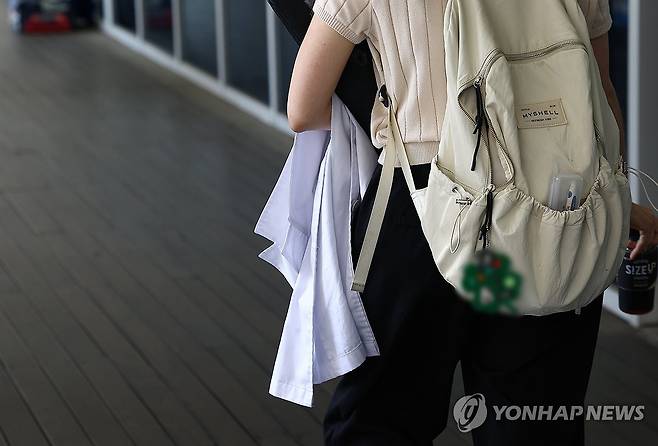 의대생 복귀 상황은? (서울=연합뉴스) 김성민 기자 = 정부와 교육계가 '의대 교육 정상화 방안'을 논의하는 가운데 의대 총장들이 의대 본과 4학년이 추가로 의사국가시험(국시)를 치를 수 있도록 정부에 건의하기로 했다.
23일 서울 시내 한 의과대학에서 한 학생이 가운을 들고 걸어가고 있다. 2025.7.23 ksm7976@yna.co.kr