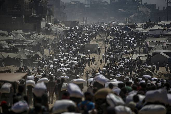 27일 가자지구 북부의 식량 배급소 근처에서 밀가루 자루를 받아가고 있는 가자 주민들. 사진=EPA 연합뉴스