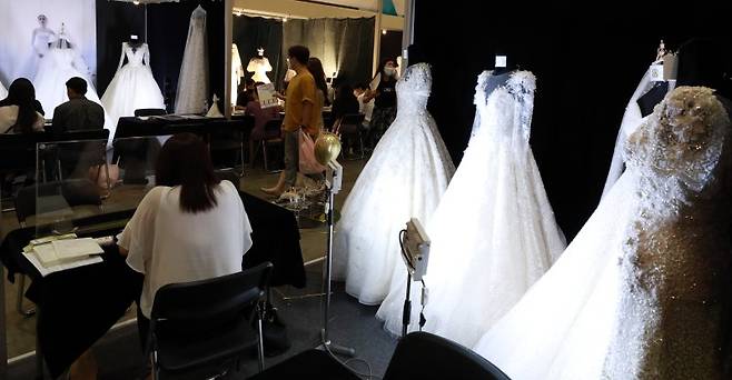 서울 강남구 코엑스에서 열린 2020년 추계 제54회 웨덱스코리아 웨딩박람회를 찾은 예비 부부들이 웨딩드레스 상담을 받고 있다. 뉴시스