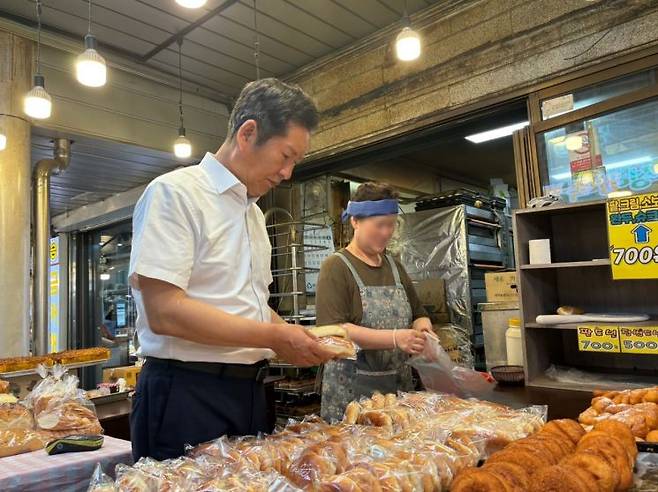 30일 인천 계양산전통시장에 방문한 정청래 민주당 당대표 후보가 한 빵집에서 빵을 구매하고 있다/사진=황서율 기자chestnut@
