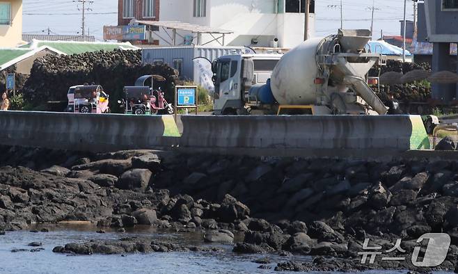 지난 1일 오전 제주에서 운행 중인 이륜차 뒤로 레미콘차량이 지나가고 있다.