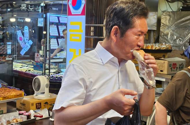 정청래 더불어민주당 대표 후보가 30일 인천 계양산전통시장에서 빵을 먹고 있다./사진=이승주 기자