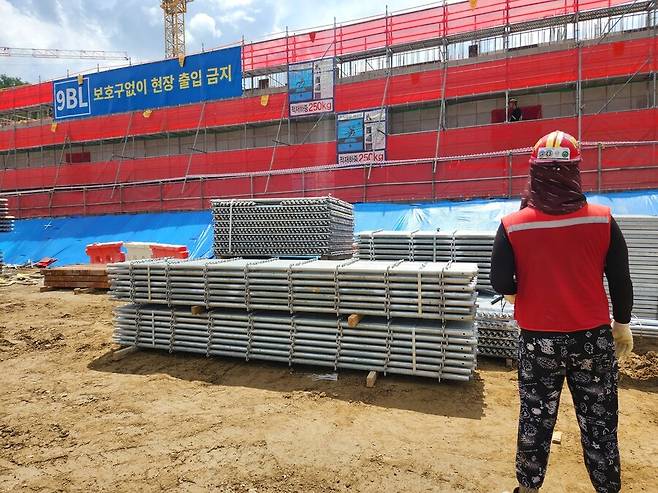 7월 22일 서울 서초구 한 건설 현장에서 한 노동자가 타워크레인 기사와 소통하며 ‘줄걸이 작업’을 준비하고 있다. 장필수 기자 feel@hani.co.kr