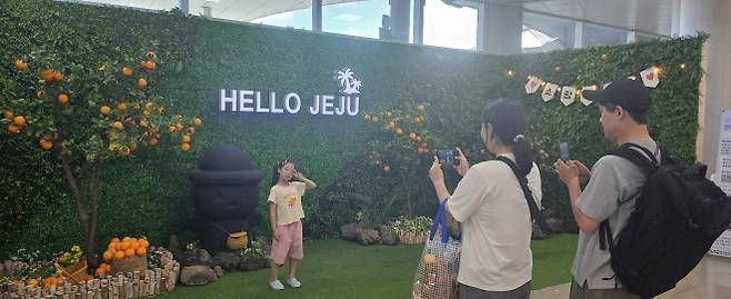 제주국제공항 3층 출발장 입구 앞에 제주 감귤 포토존에서 가족여행을 온 관광객이 사진을 찍고 있다. 제주 강동삼 기자