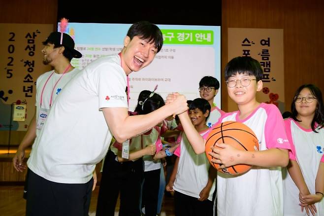 삼성 다문화청소년 스포츠클래스 여름캠프가 열린 7일 경기 고양 삼성화재 글로벌캠퍼스에서 최성모(왼쪽) 서울 삼성 썬더스 농구단 선수가 참가한 학생에게 농구 기술을 가르쳐주며 포즈를 취하고 있다. 제일기획 제공