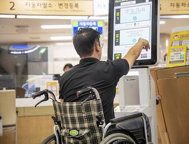 서울 용산구청 자동차등록팀 민원창구 앞에 설치된 유니버설 디자인 키오스크를 한 주민이 사용하고 있다. 용산구 제공