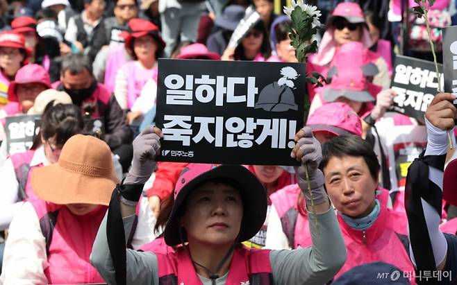 민주노총 조합원이 23일 오후 서울 중구 서울고용노동청 앞에서 열린 '작업중지권 쟁취! 노동자 참여 산업안전보건법 개정 민주노총 결의대회'에서 국화꽃과 손피켓을 들고 있다. 2025.4.23/사진=뉴스1 Copyright (C) 뉴스1. All rights reserved. 무단 전재 및 재배포, AI학습 이용 금지.