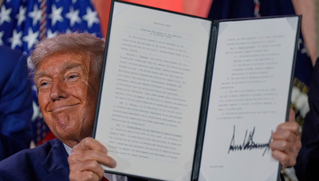 도널드 트럼프 미국 대통령이 7월 23일(현지시간) 워싱턴의 앤드루 W. 멜론 강당에서 열린 AI 정상회의에 참석해 연설한 뒤 서명한 AI 관련 행정명령을 들어 보이고 있다. / AP·뉴시스