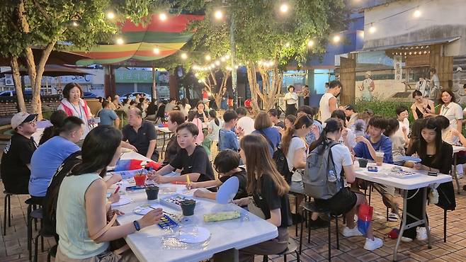 16일 오후 대구 중구청이 운영하는 근대골목 밤마실 투어 참가자들이 약령시한의약박물관 광장에서 체험 프로그램을 즐기고 있다. 광장 한쪽에서는 장구 공연이 이어지며 흥을 더했다. 조윤화 기자