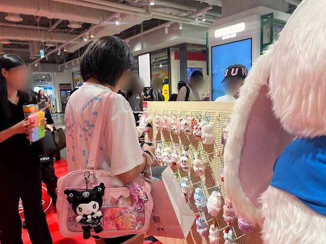 지난 14일 오전 서울 용산 아이파크몰에서 가방을 캐릭터 키링으로 꾸민 한 고객이 키링상품을 구경하고 있다. 사진=김현지 기자