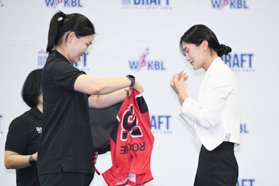 박지수(오른쪽)가 박정은 BNK 감독으로부터 유니폼을 전달받고 있다. /사진=WKBL 제공