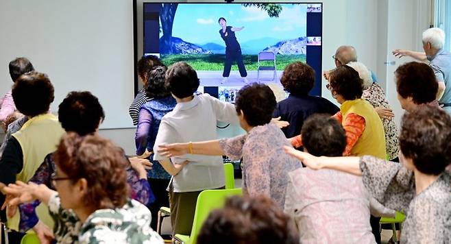 지난 6월 18일 부평구 더샵부평센트럴시티아파트 경로당에서 어르신들이 스마트경로당 스튜디오에서 제작된 영상을 보며 건강체조를 하고 있다. 사진=인천시
