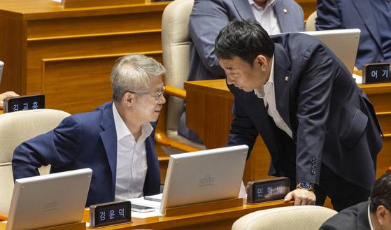 더불어민주당에서 '검찰개혁'안 마련을 주도하는 민형배 의원(왼쪽)와 김용민 의원이 25일 국회에서 열린 본회의에서 도중 대화하고 있다. 민 의원은 당 검찰개혁특위 위원장을 맡고 있다. 연합뉴스