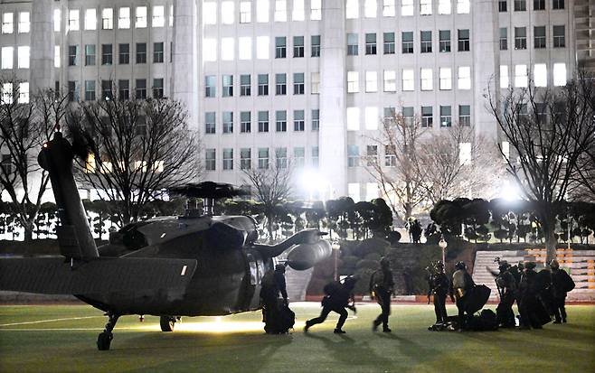 지난해 12월3일 비상계엄의 밤, 국회 운동장 건너편 담장 아래 수풀 속으로 숨어 찍은 사진. 국회의사당 건물을 배경으로 헬기에서 내리는 계엄군을 포착했다. /도준석 제공