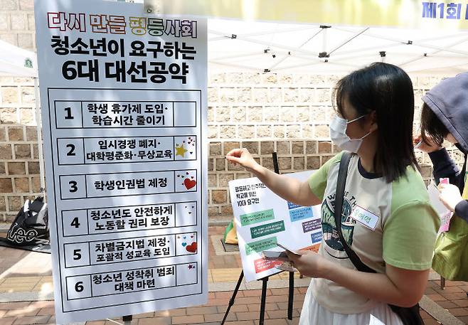 중구 덕수궁 돌담길에서 열린 ‘다시 만들 세계 포럼’에서 한 참가자가 청소년들이 요구하는 6대 대선공약에 스티커를 붙이고 있다. (사진=연합뉴스)