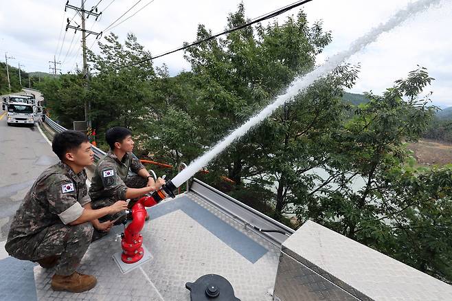 Military personnel in Gangneung, Gangwon Province, pour water brought in by military water tanks into the Obong Reservoir, as the city struggles with one of its worst droughts in history, Tuesday. (Yonhap)