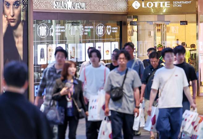 서울 시내 롯데면세점에서 외국인 관광객들이 쇼핑을 마친 뒤 걸음을 옮기고 있다. /뉴스1