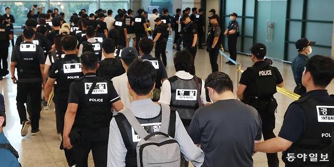 필리핀에서 검거된 한국인 범죄 피의자 49명이 3일 인천국제공항에서 수갑을 차고 호송관에게 양팔이 붙들린 채 입국하고 있다. 경찰은 필리핀 당국과 협조해 전세기를 투입해 이들을 강제 송환했다. 인천=신원건 기자 laputa@donga.com