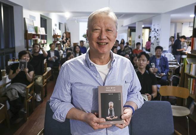 박용만 전 대한상공회의소 회장이 두 번째 저서 <지금이 쌓여서 피어나는 인생>을 출간했다. 지난 3일 저녁 서울 종로구 서촌 북카페에서 출간 기념 북콘서트에서 박 전 회장이 참석자들과 함께 책을 들어보이고 있다. 임형택 기자