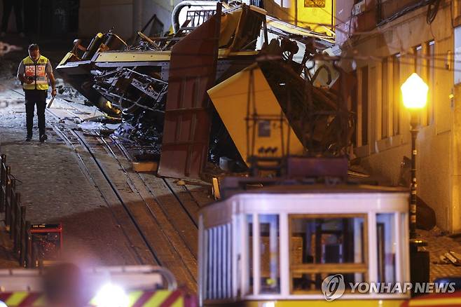 포르투갈 리스본 푸니쿨라 탈선 사고 (리스본 EPA=연합뉴스) 한 경찰관이 3일(현지시간) 포르투갈 리스본에서 포르투갈 리스본에서 발생한 푸니쿨라 탈선 사고 현장을 지나고 있다. 2025.9.3