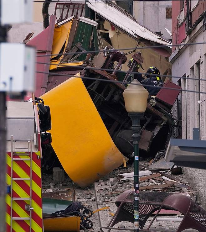 3일 포르투갈 수도 리스본의 명물 전차 ‘푸니쿨라’의 탈선 현장. 노란색 열차가 산산이 부서져 있다. 이 사고로 17명이 숨지고 한국인 여성 1명을 포함해 최소 21명이 다쳤다. 리스본=AP 뉴시스