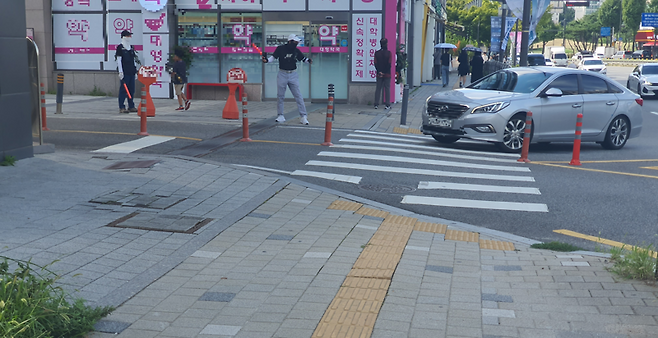 지난 3일 경광봉을 든 약국 직원들이 아산병원 인근에 위치한 잠실올림픽공원 아이파크 단지 주차장으로 차량 진입을 유도하고 있다. 아파트 입주민 노모씨(50대)은 "약국 셔틀 차량이 수시로 제집 드나 들듯이 주차장을 드나든다"며 "입주민은 강제로 다른 출입구로 다녀야한다"고 불만을 토로했다. 사진=최승한 기자