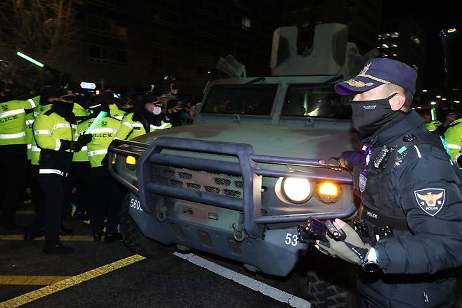 윤석열이 2024년 12월3일 비상계엄을 선포한 뒤에 서울 영등포구 국회의사당 밖에 경찰관들과 군용 차량이 배치돼 있다. EPA 연합뉴스