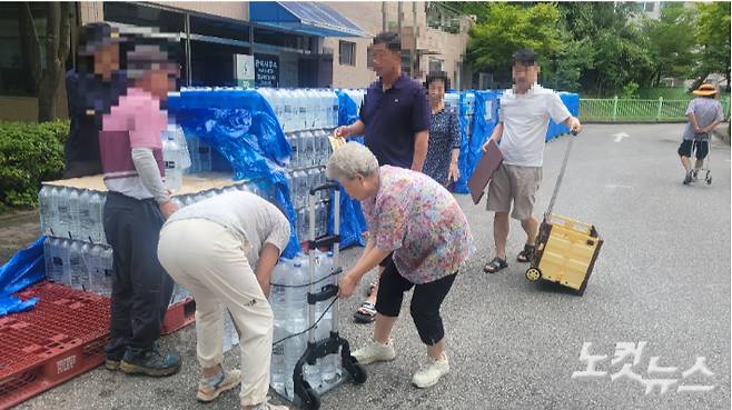 생수를 수레에 싣고 있는 주민. 전영래 기자