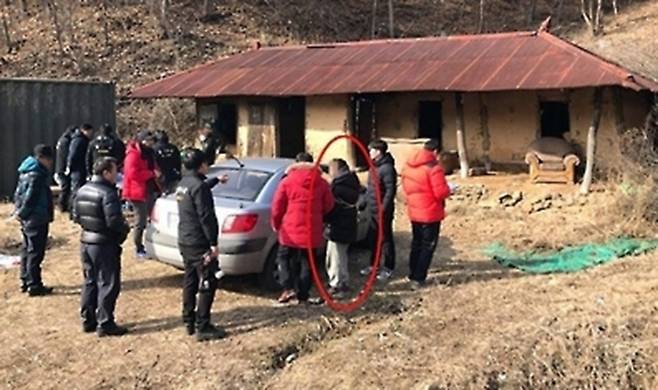 2017년 1월 홍천군의 한 폐가에서 한씨(빨간색 동그라미)가 범행을 재연하고 있다. 연합뉴스