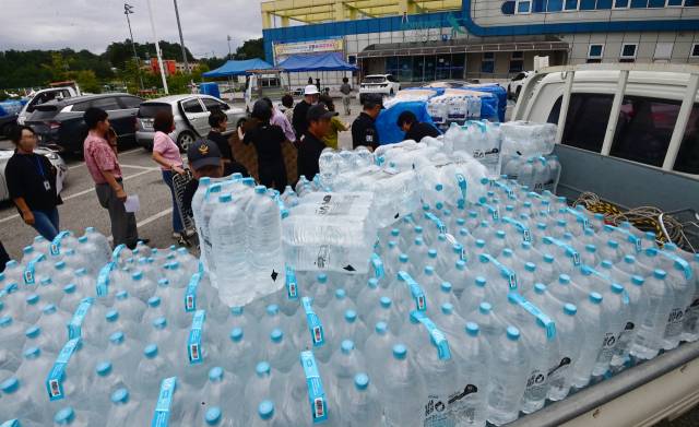 5일 강원 강릉시 강남동 강남축구공원에서 주민들에게 생수를 나눠주고 있다. 강릉시는 수돗물 사용을 조금이라도 줄이고자 저수율 10% 이하에 배부하기로 했던 218만개의 생수를 1인당 12ℓ씩 배부하고 있다. 연합뉴스