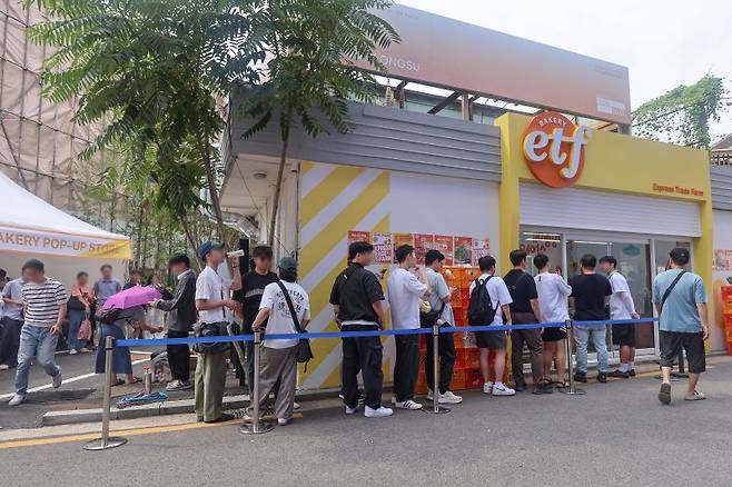 지난달 31일 서울 성동구 글로우 성수에 마련된 경제유튜버 슈카의 ETF 베이커리 팝업 스토어 앞에 빵을 사려는 시민들이 줄을 서고 있다. 연합뉴스