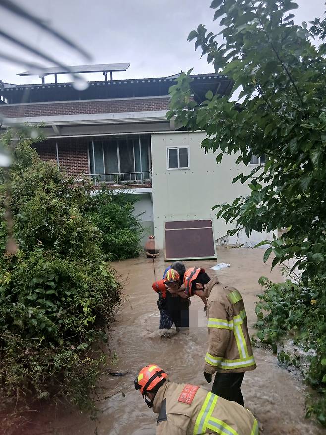 7일 오전 6시34분쯤 "전주시 완산구 색장동 주택 1층에 물이 차 2층에 2명이 갇혀 있다"는 신고를 접수한 소방당국이 현장에 출동해 해당 주택에서 주민 2명을 구조하고 있다. 사진 전북특별자치도소방본부