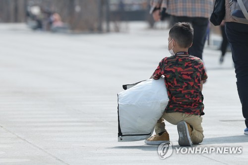 햇볕 아래 앉은 아이. 연합뉴스